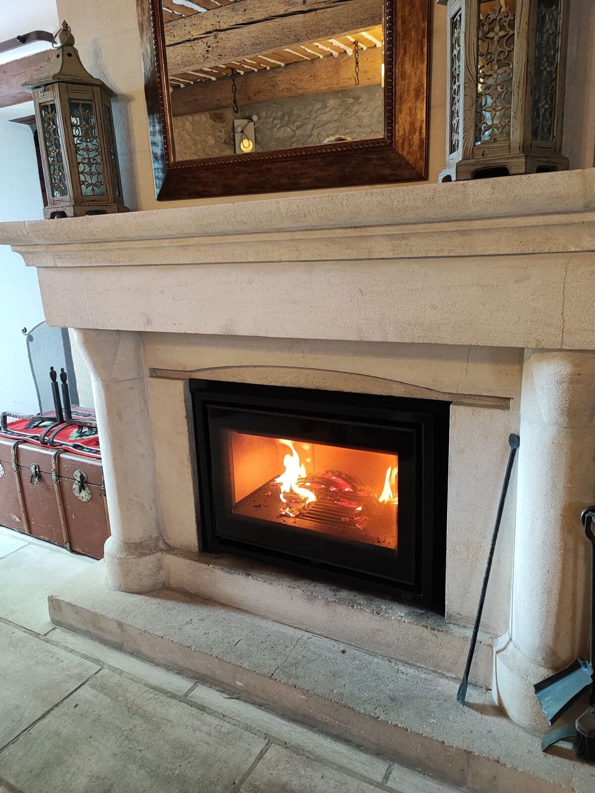 Insert bois KUNST encastré dans une cheminée en pierre à Cavaillon, avec habillage en acier microperforé sur mesure – installation Flamme Concept