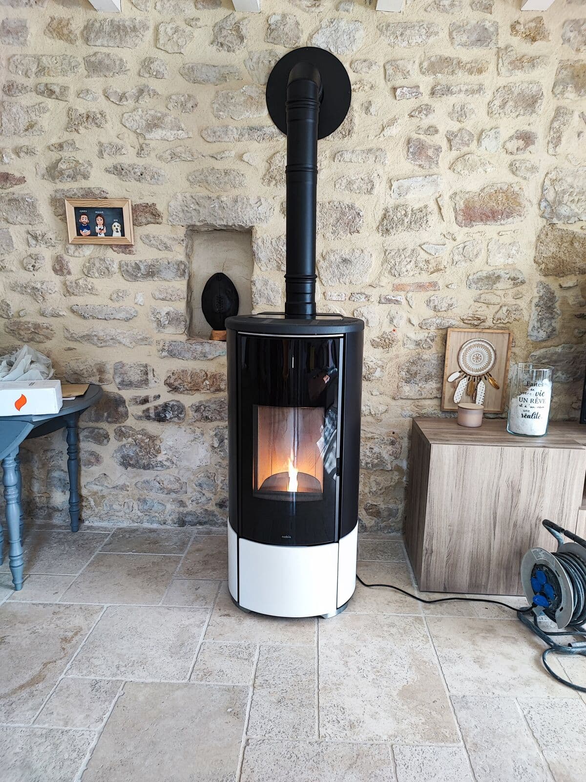 Poêle à granulé (pellet) Nobis A8 top Coax installé en ventouse, il est devant un ur en pierre typique des mas dans le Vaucluse (84) et est allumé avec une grande flamme