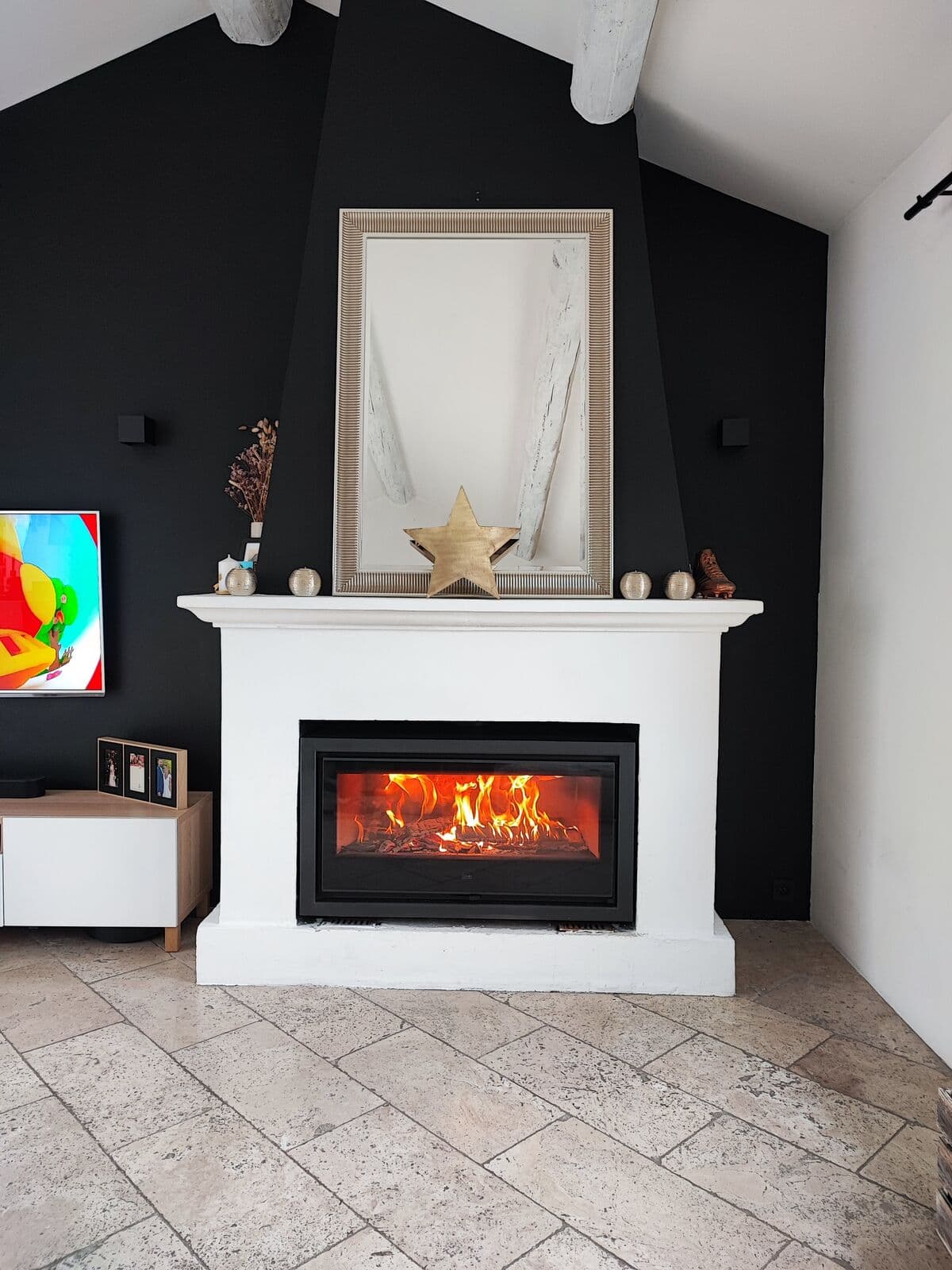 Poêle à bois Denia Panoramic installé à Avignon dans une cheminée contemporaine blanche avec mur noir, réalisé par Flamme Concept